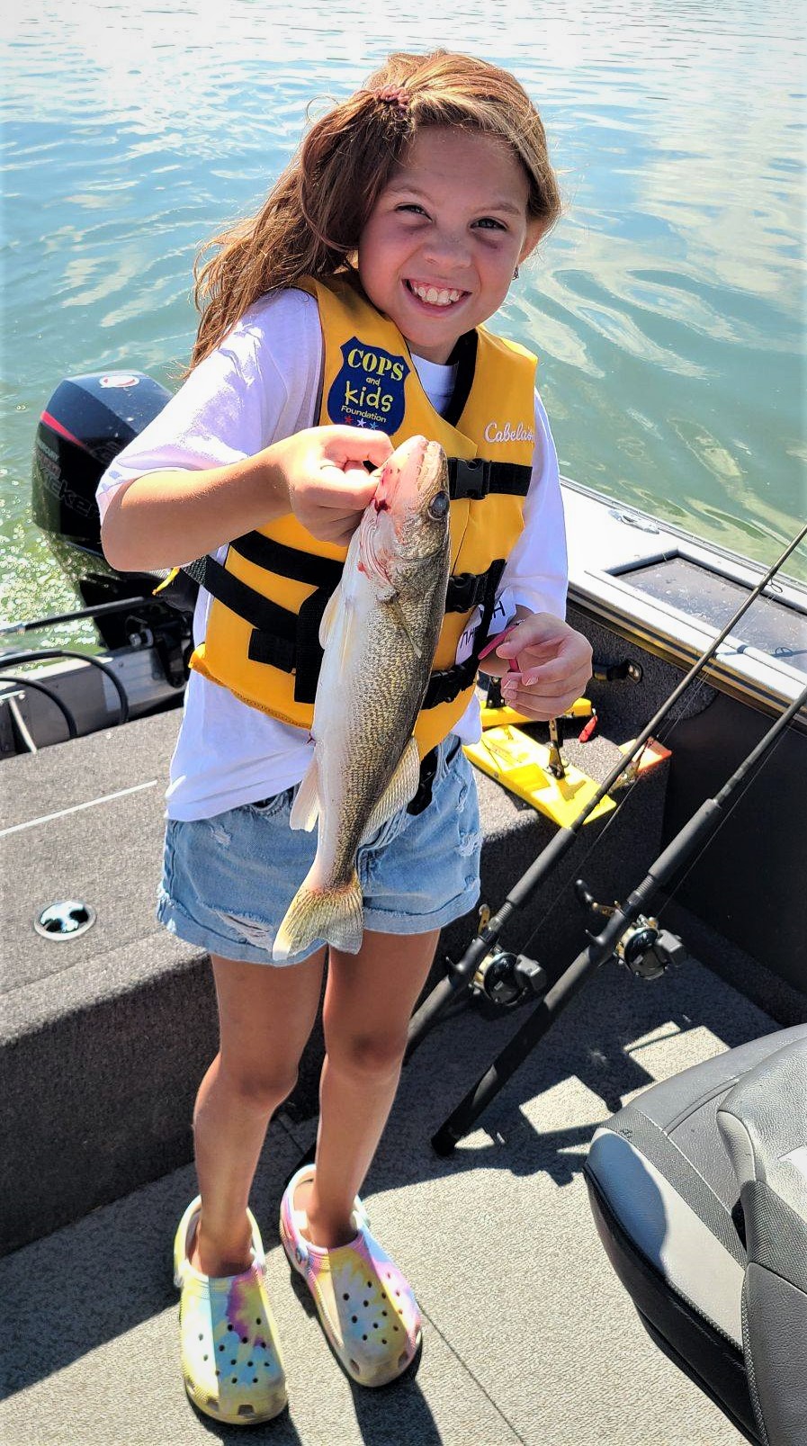GIRL HOLDING FISH AT COPS & BOBBERS EVENT